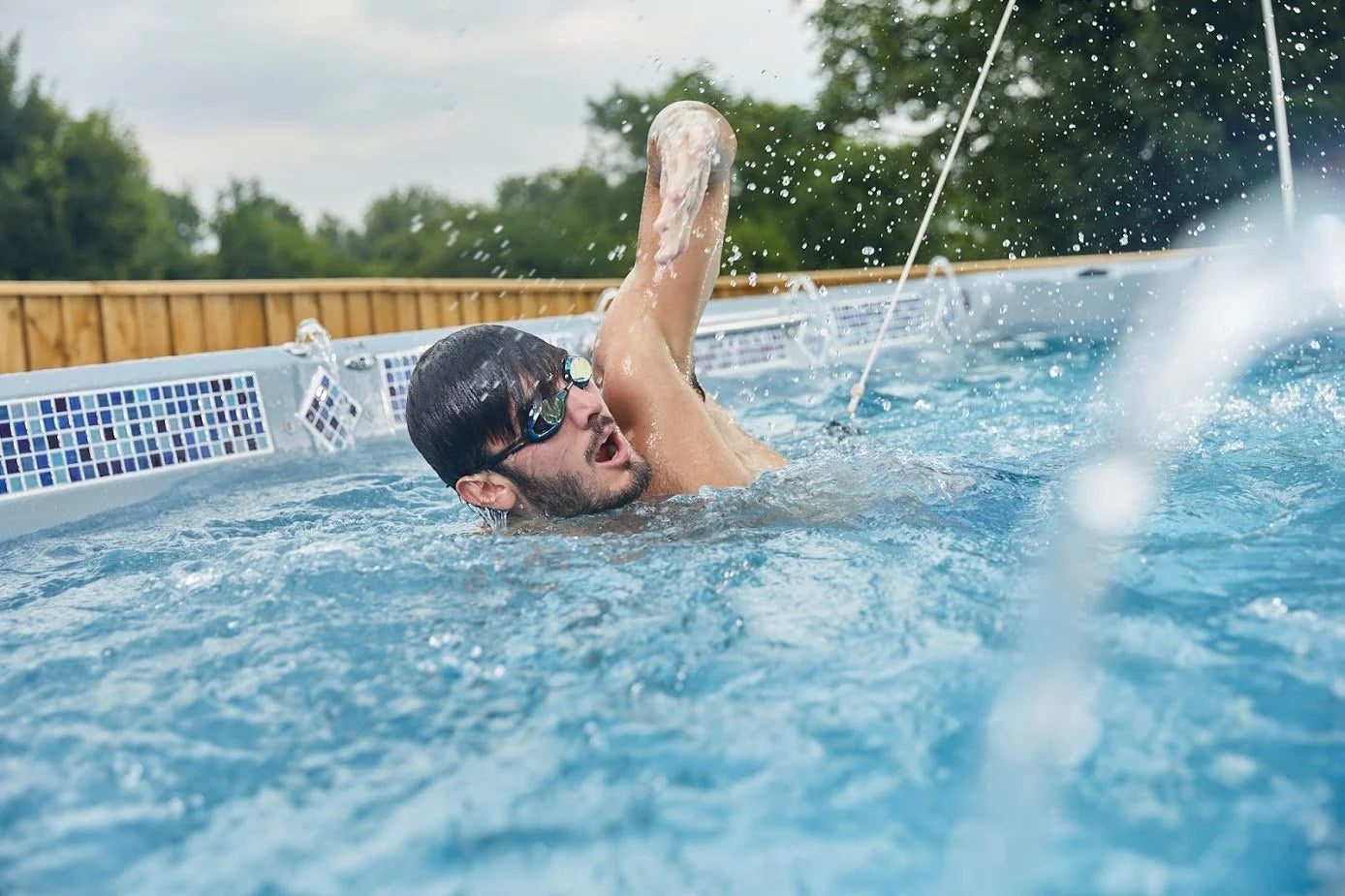 A man swimming in a swim spa with wearing goggles