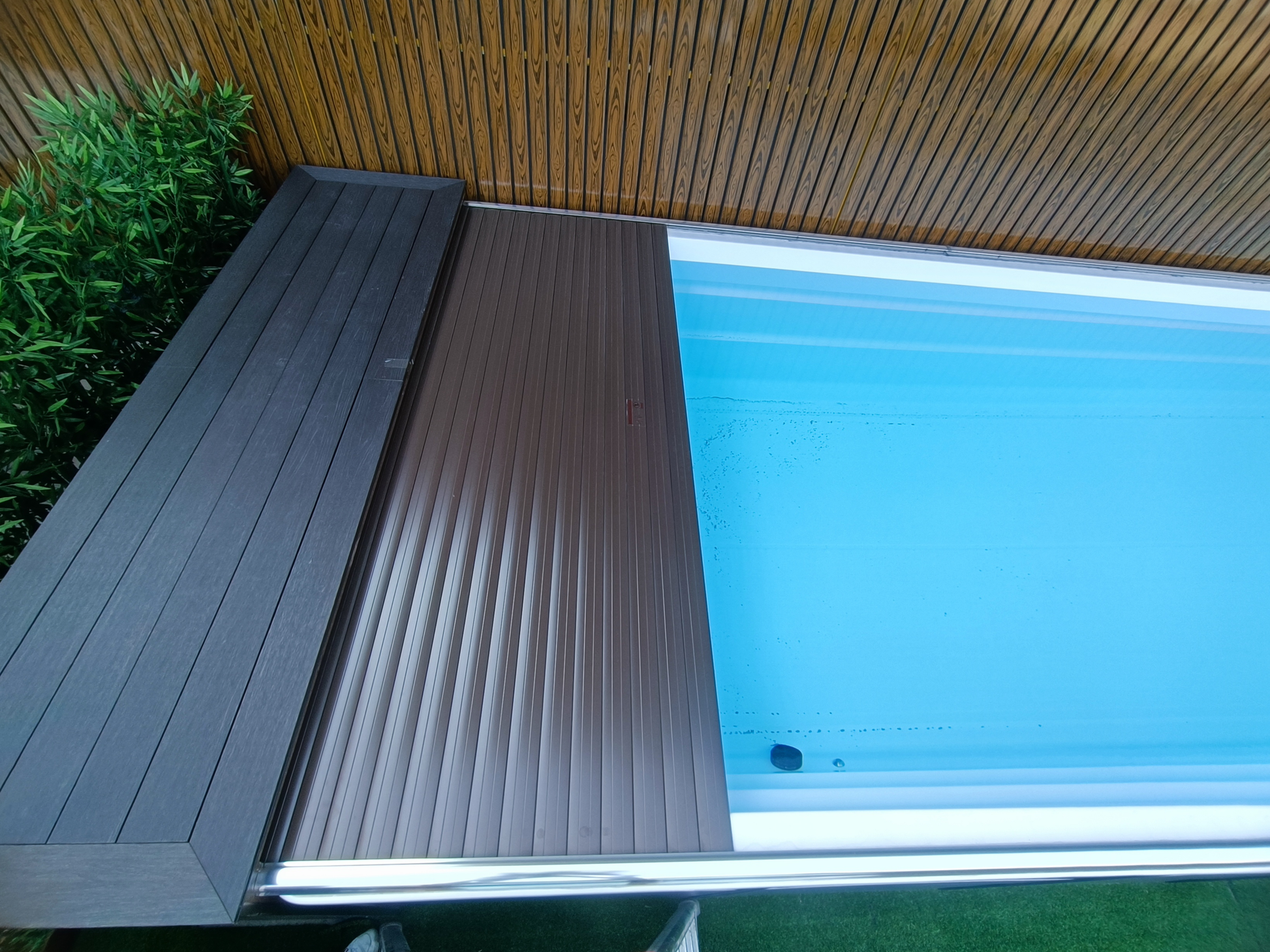 swim spa fitted with automated slatted swim spa cover partially open