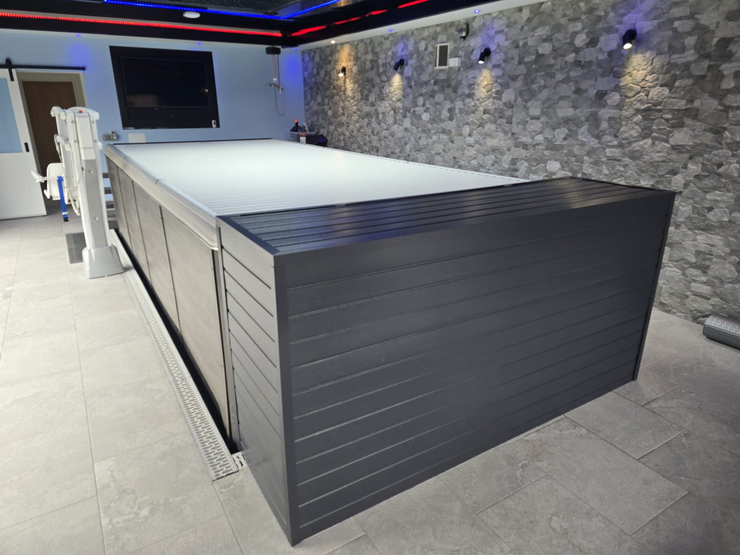 EZGlide Automated cover closed on a swim spa installed inside a room