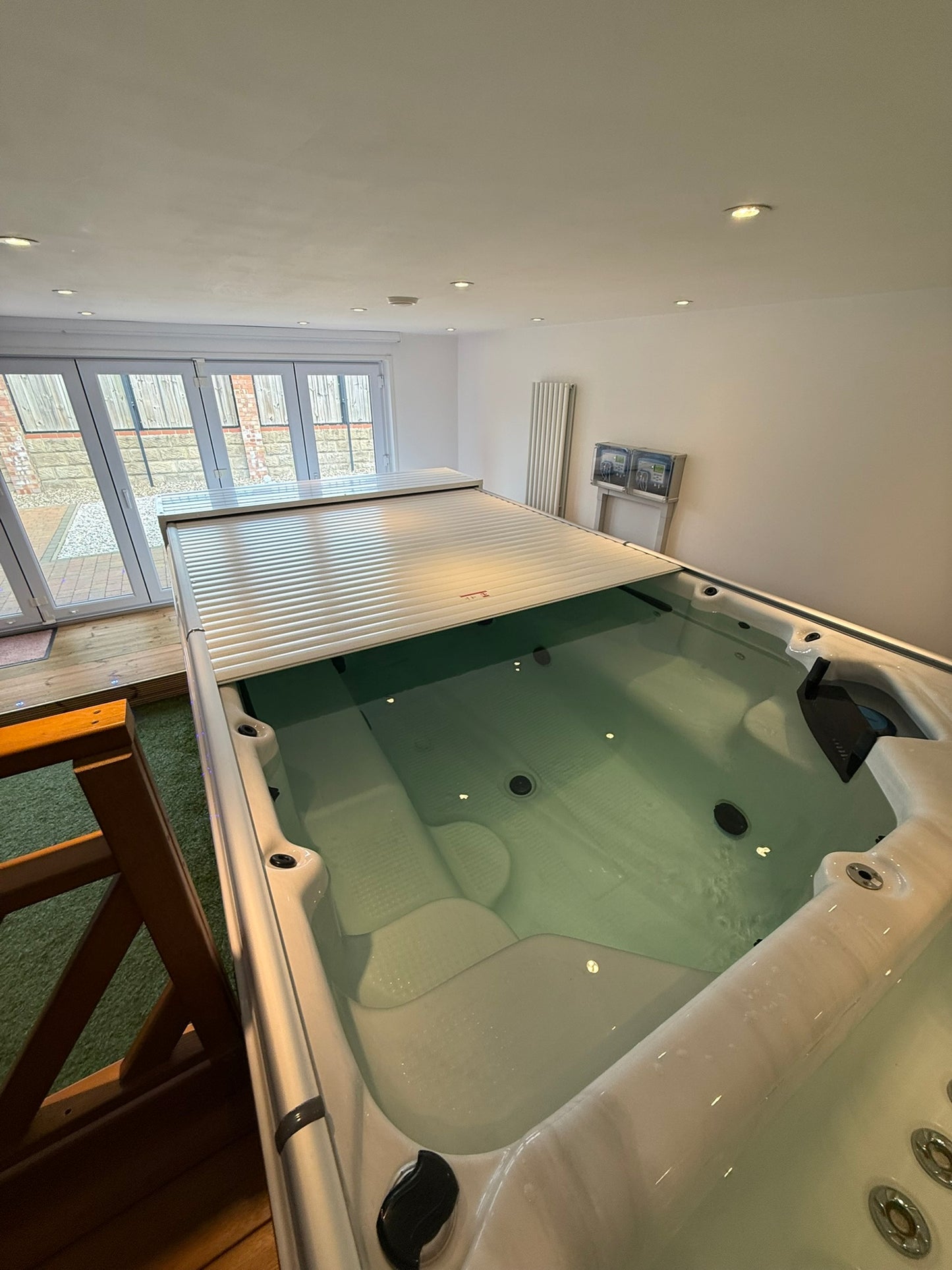 EZ Glide automated cover partially open on a swim spa installed inside