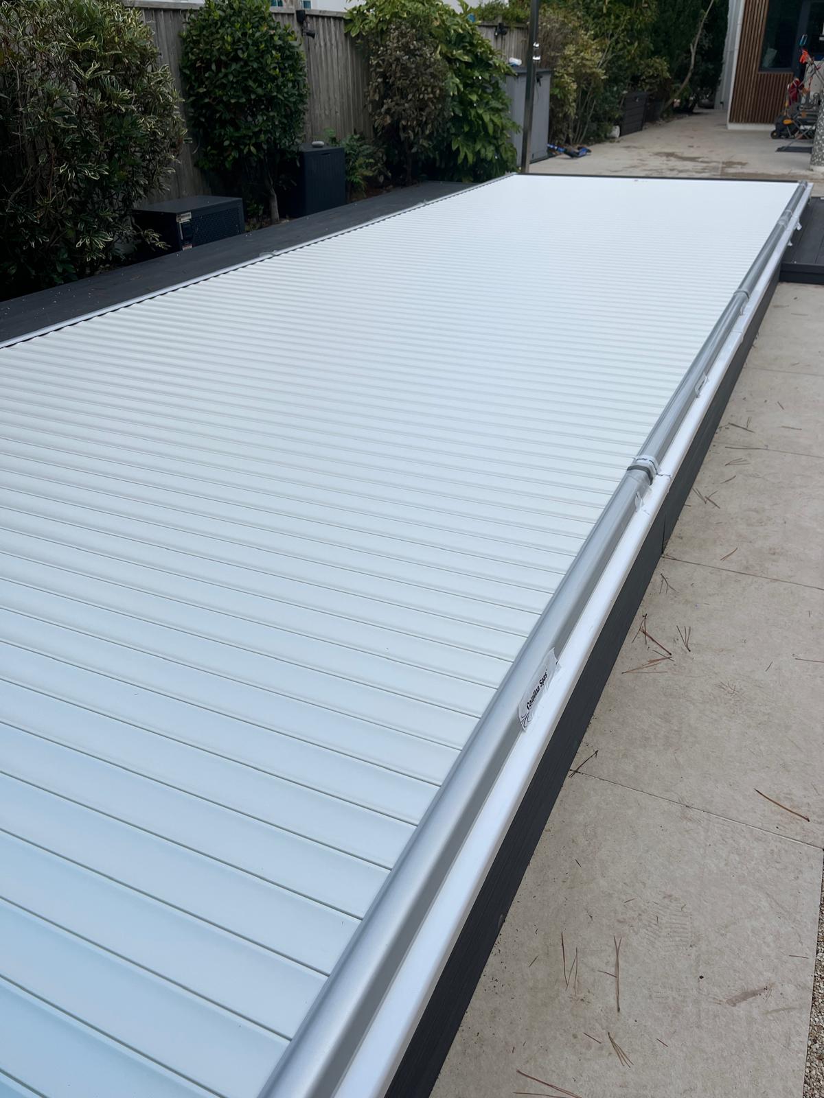 Automated swim spa cover closed in a garden