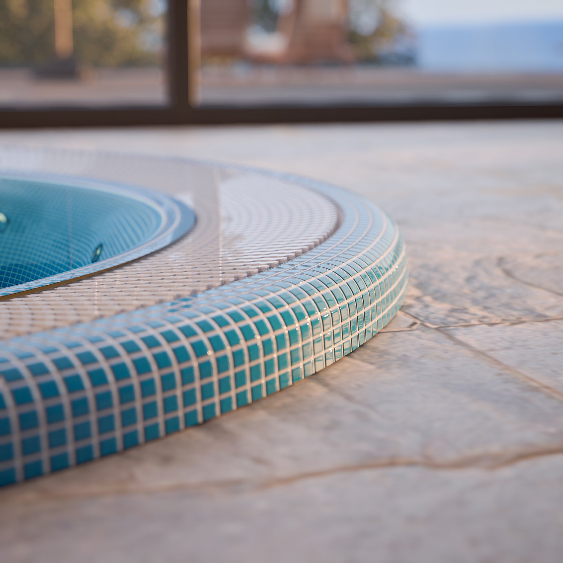 edge of a mosaic hot tub installed inground 