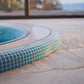 edge of a mosaic hot tub installed inground 