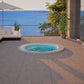 Outdoor mosaic hot tub with a view of the ocean and lounge area